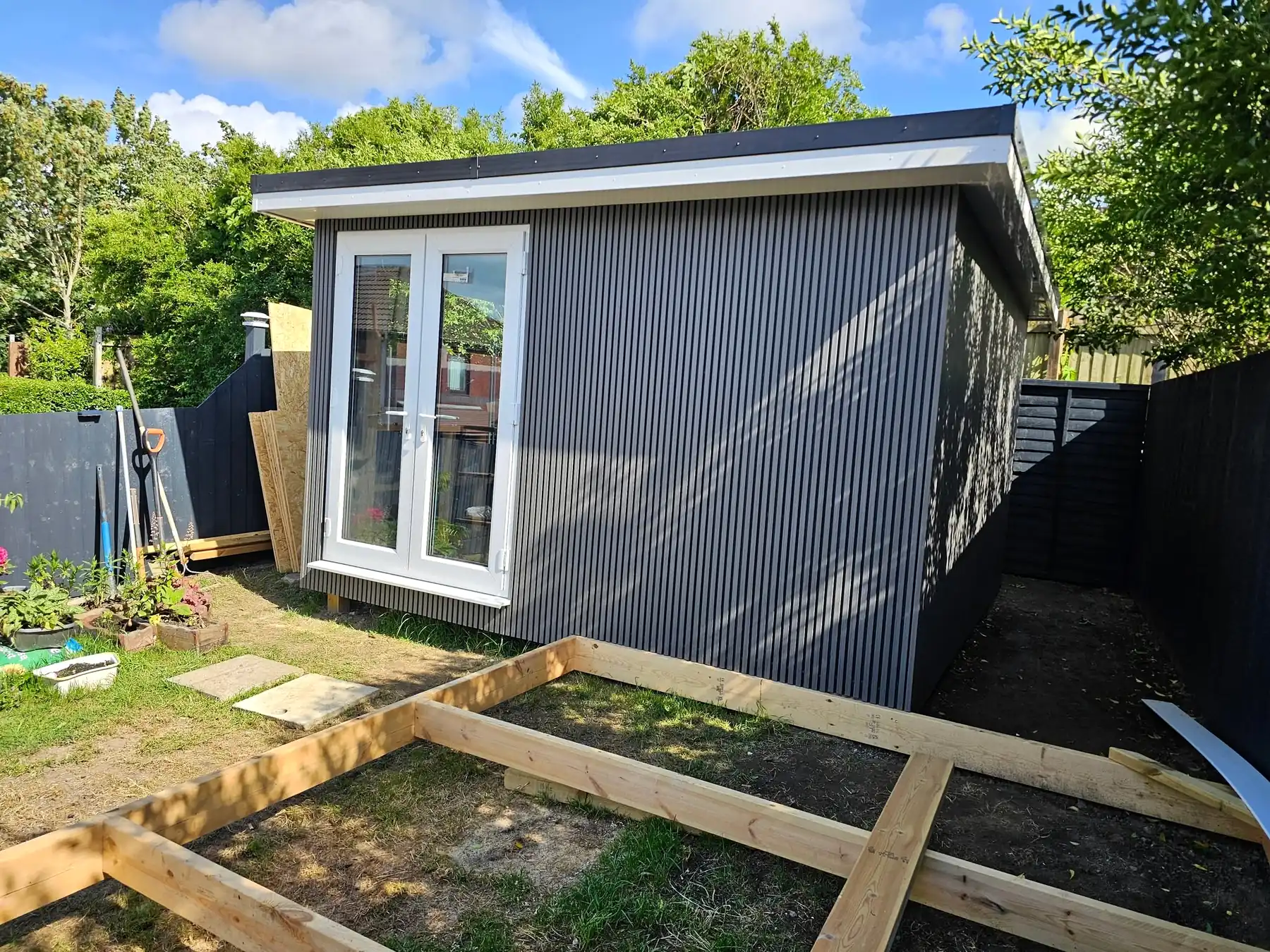 Finished garden room with French doors and grey cladding