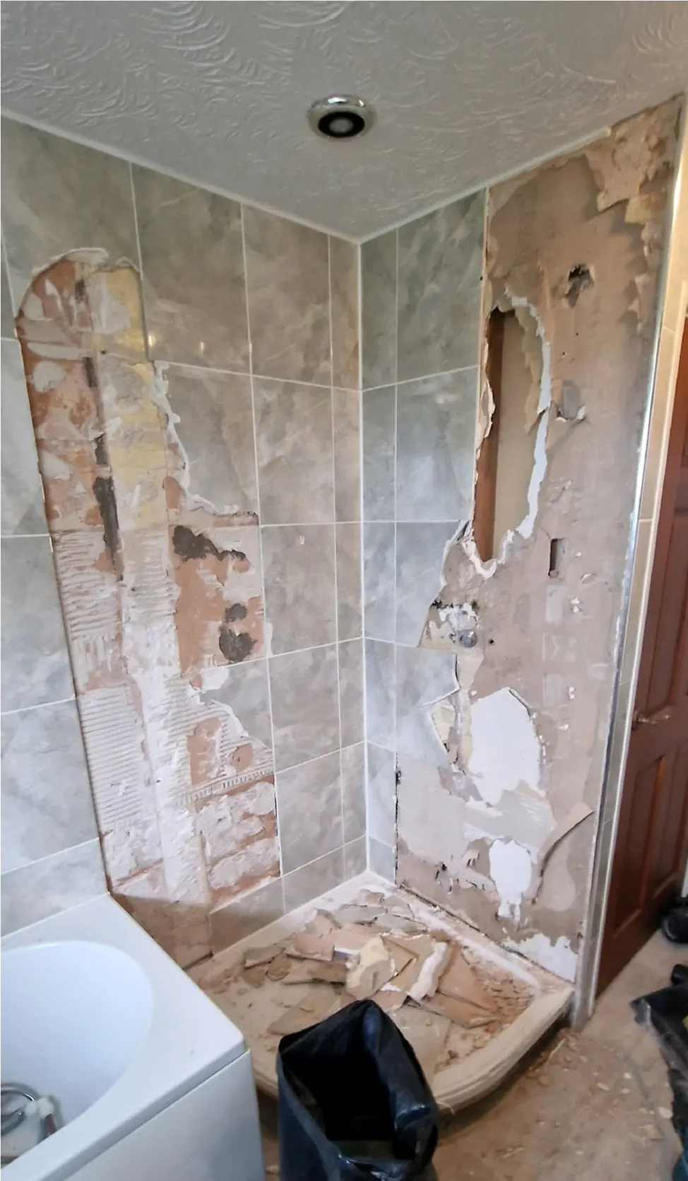 Before: shower corner with damaged walls