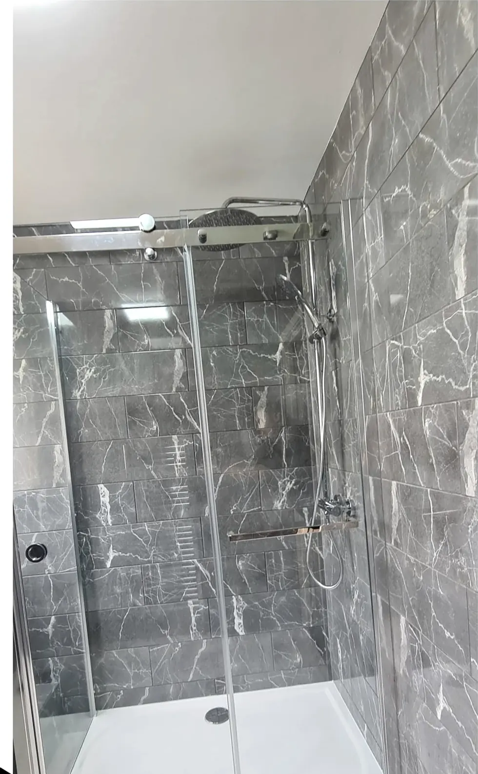 After: walk-in shower with grey marble-effect walls